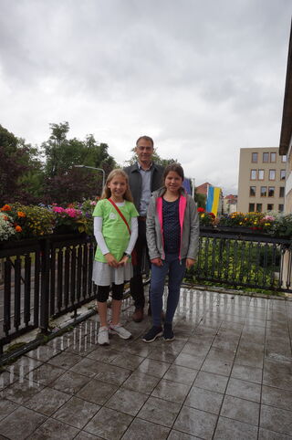zwei Kinder mit Oberbürgermeister Peter Kleine auf dem Balkon der Stadtverwaltung
