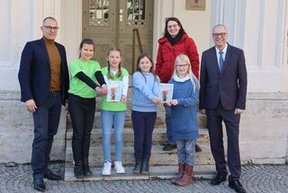 Oberbürgermeister, Bürgermeister und Kinderbeauftragte mit 4 Kindern zeigen den Rathausführer