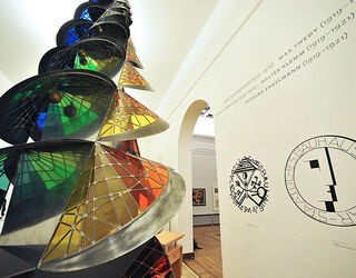 Bauhaus Museum Weimar Im Hintergrund sind kunstvolle Wandgrafiken zu sehen, die die Verbindung zur Bauhaus-Bewegung verdeutlichen.