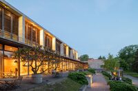 Der einladende Außenbereich der Weimarhalle mit Tischen und Stühlen, ideal für gesellige Zusammenkünfte in der Dämmerung.