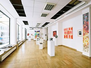 Moderne Kunstgalerie mit vielfältigen Kunstwerken und Skulpturen Ein heller Ausstellungsraum mit weißen Wänden, in dem verschiedene Kunstwerke und Skulpturen auf Podesten präsentiert werden.