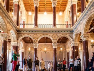 Führung durch die Schlosskapelle im Stadtschloss Eine Gruppe von Menschen steht in einem prächtigen Raum mit hohen Säulen und kunstvollen Deckenverzierungen.