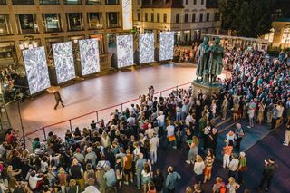 Kunstfest Weimar, Eroeffnung Eine große Menschenmenge versammelt sich auf dem Theaterplatz, während ein Tänzer vor mehreren großen Bildschirmen zur Eroeffnung des Kunstfestsauftritt.