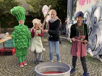 vier Kinder in Kostümen vor einer Zinnwanne