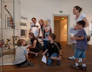 Lange Nacht der Museen Die Besucher im Museum zeigen Interesse an den Ausstellungsstücken, während sie sich um eine Vitrine mit einer Geige versammeln.