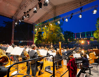 Staatskapelle Weimar beim Open Air im Weimarhallenpark Die Staatskapelle Weimar spielt im Weimarhallenpark auf einer großen Bühne unter freiem Himmel.