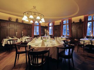 Ein elegantes Restaurant mit Holzvertäfelung, sanfter Beleuchtung und schön gedeckten Tischen für ein romantisches Dinner.