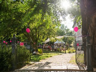 Meisterkurse Weimar Ein sonniger Garten mit bunten Luftballons, in dem Menschen an einem Tisch sitzen und ein Konzert der Weimarer Meisterkurse genießen.