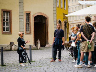 Stadtführung vot Goethes Wohnhaus Menschen hören in Weimar einer Stadtführerin vor Goethes Wohnhaus zu.