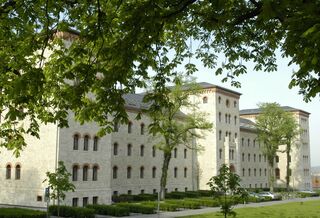 Eindrucksvolle Fassade des Hochschulzentrums am Horn Das Hochschulzentrum am Horn mit einer beeindruckenden Fassade aus hellem Stein und vielen Fenstern, umgeben von Bäumen.