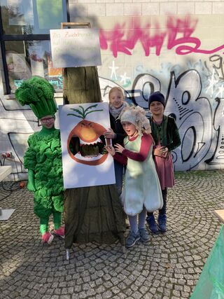 Kinder vor einem selbst gebastelten Wurfspiel. 