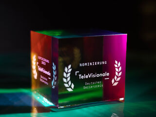 Ein farbenfroher, prismatischer Preis mit der Aufschrift 'Nominierung 2023' und dem Logo der TeleVisionale.