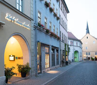 Ein malerischer Blick auf das Hotel Anna Amalia, umgeben von historischen Gebäuden und blühenden Fensterkästen.