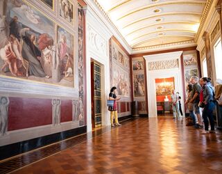 Führung durch das Dichterzimmer Goethe im Stadtschloss Im eleganten Raum stehen Menschen, während eine Frau mit einem Mikrofon eine Führung durch die beeindruckenden Kunstwerke leitet.