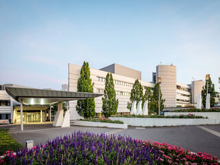 Einladender Eingangsbereich des Sophien- und Hudeland-Klinikums Das Sophien- und Hufeland-Klinikum mit einer eleganten Überdachung und gepflegten Gärten, umgeben von bunten Blumen und hohen Bäumen.